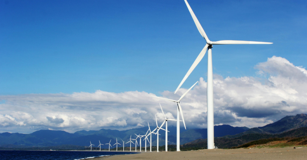 White Wind Turbines on Gray Sand Near Body of Water